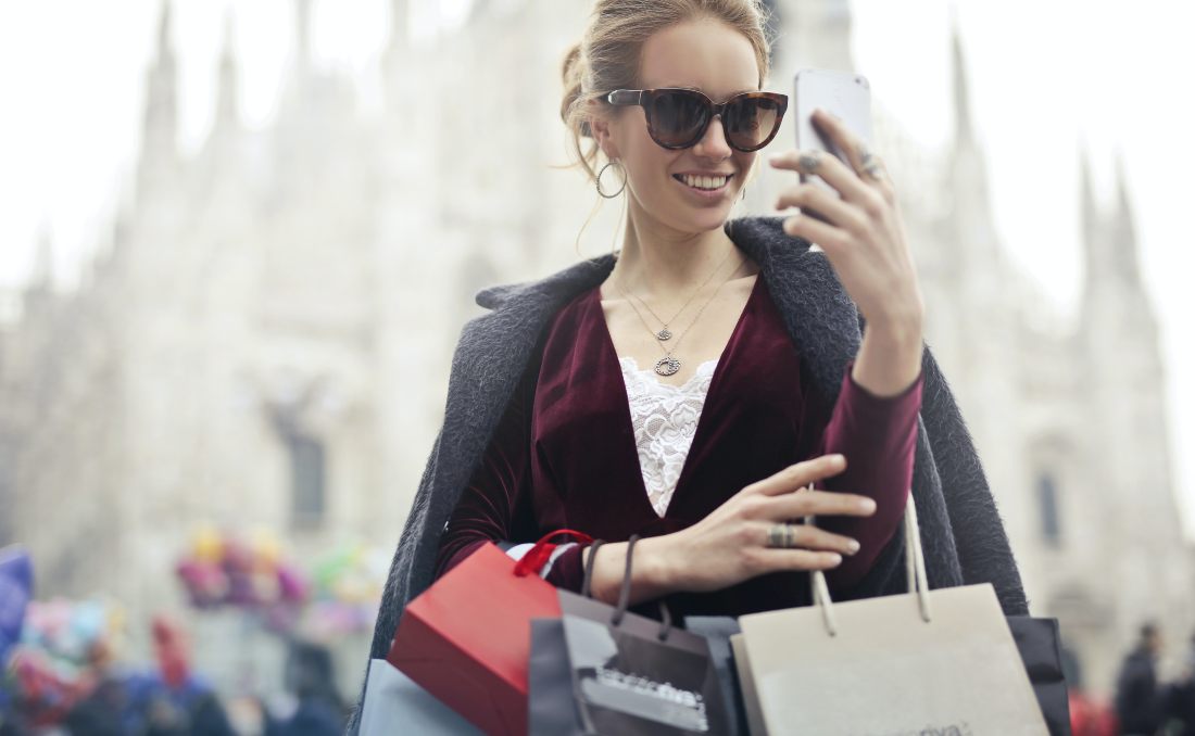 A girl with shopping bags is smiling