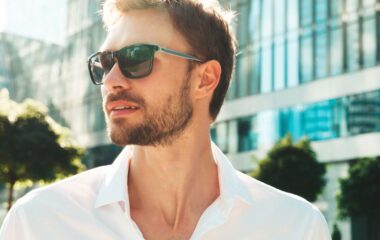 Muškarac u beloj košulji nosi moderne muške naočare za sunce u urbanom okruženju.